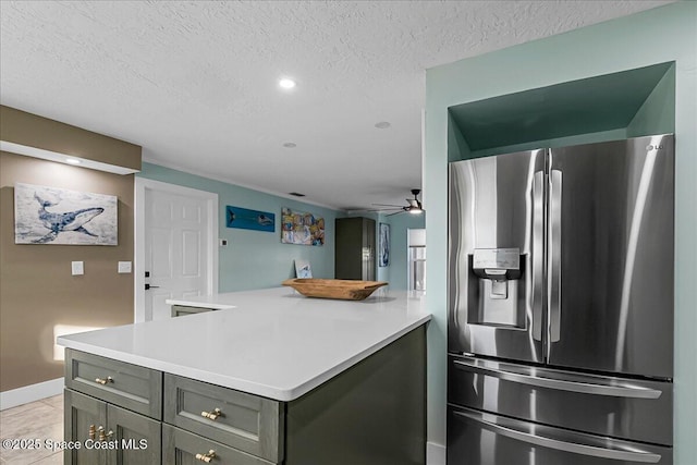 kitchen featuring ceiling fan, stainless steel fridge, a textured ceiling, and gray cabinets