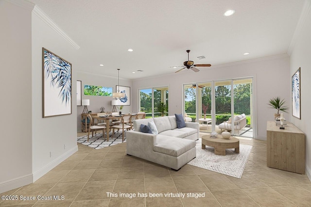 living area featuring a wealth of natural light, light tile patterned flooring, and crown molding