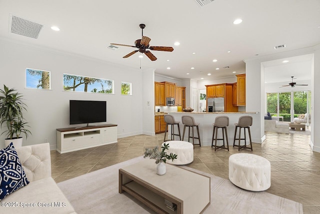 living room with ceiling fan, light tile patterned flooring, and ornamental molding