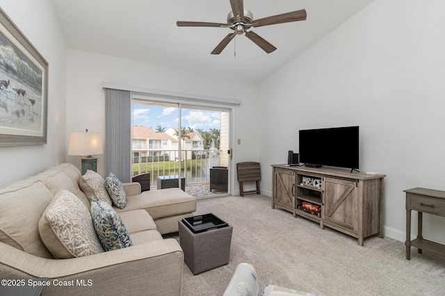 carpeted living room with ceiling fan and vaulted ceiling