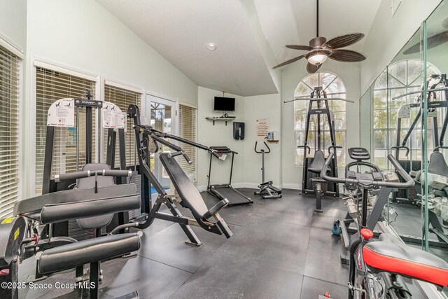 gym featuring a textured ceiling, ceiling fan, and vaulted ceiling