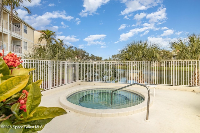 view of swimming pool featuring a patio, a water view, and a hot tub