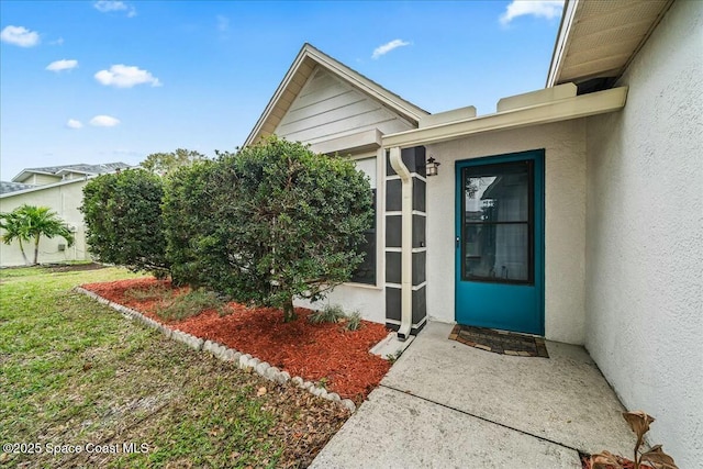 property entrance featuring a lawn