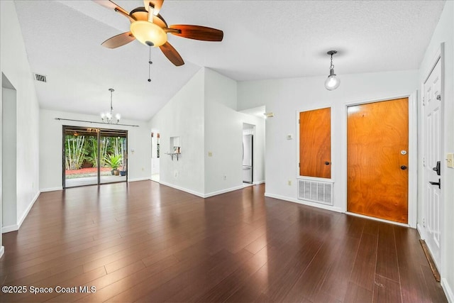 interior space featuring a textured ceiling, ceiling fan with notable chandelier, dark wood-type flooring, and lofted ceiling