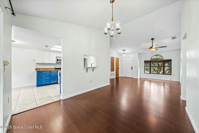 unfurnished living room with ceiling fan with notable chandelier, light hardwood / wood-style flooring, and lofted ceiling