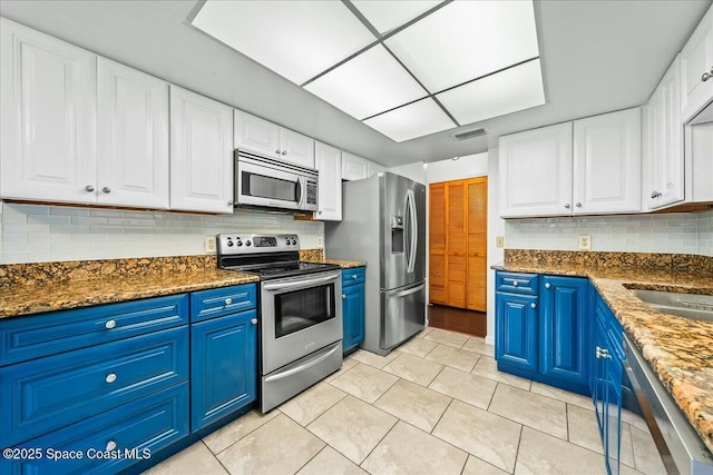 kitchen with blue cabinetry, white cabinets, and stainless steel appliances