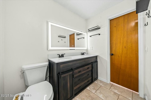 bathroom with tile patterned floors, vanity, and toilet