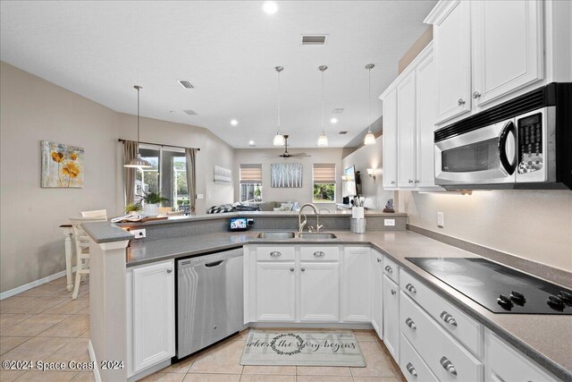 kitchen with ceiling fan, appliances with stainless steel finishes, decorative light fixtures, light tile patterned flooring, and kitchen peninsula