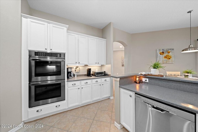 kitchen with white cabinets, decorative light fixtures, stainless steel appliances, and light tile patterned flooring