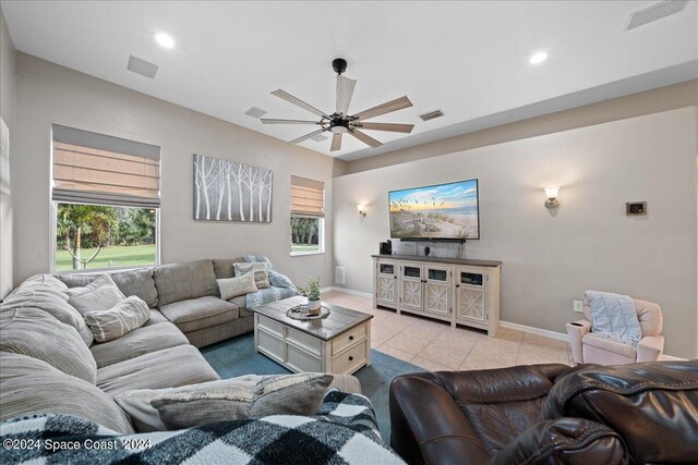 living room with a wealth of natural light, light tile patterned flooring, and ceiling fan