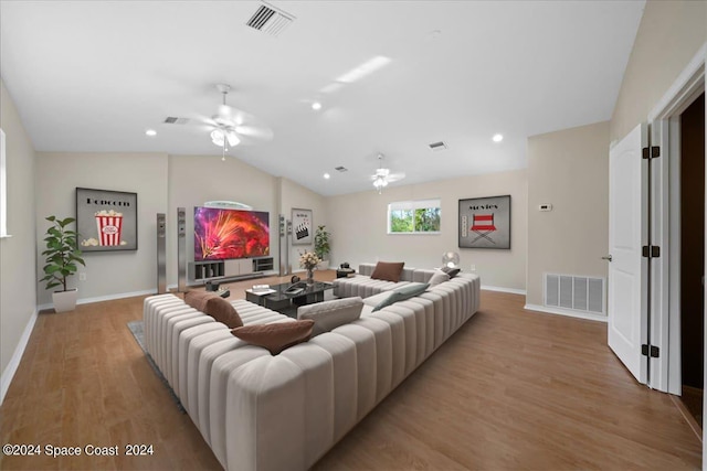 living room with light wood-type flooring, vaulted ceiling, and ceiling fan