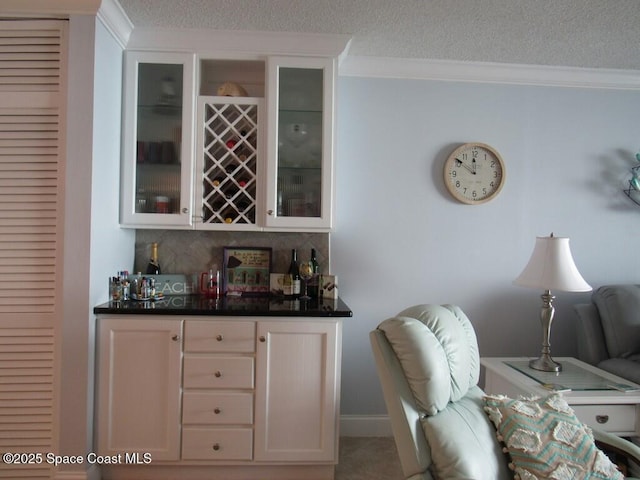 bar featuring backsplash, crown molding, and white cabinets