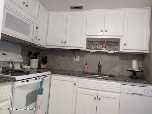 kitchen with sink, white appliances, white cabinets, and backsplash