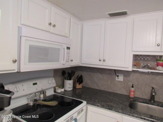 kitchen featuring decorative backsplash, white appliances, white cabinetry, and sink