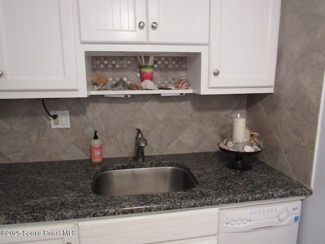 kitchen with tasteful backsplash, dark stone counters, sink, dishwasher, and white cabinetry