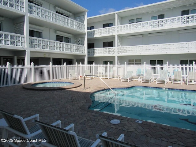 view of pool with a community hot tub and a patio area