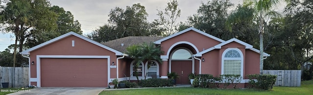 single story home with a garage and a front lawn