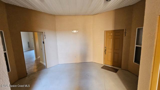 empty room featuring a towering ceiling and wood ceiling