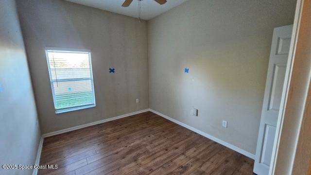 unfurnished room with dark hardwood / wood-style floors and ceiling fan