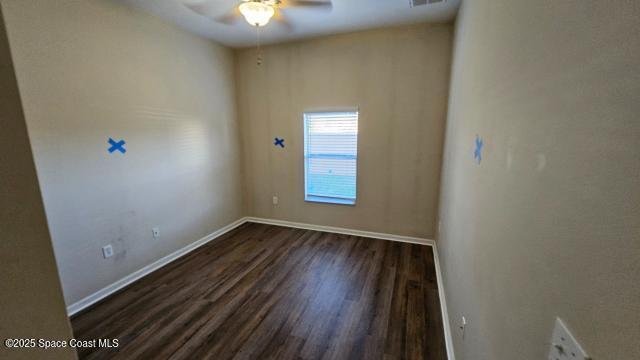 spare room with dark hardwood / wood-style flooring and ceiling fan