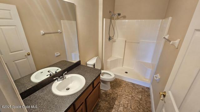 bathroom featuring vanity, toilet, and walk in shower