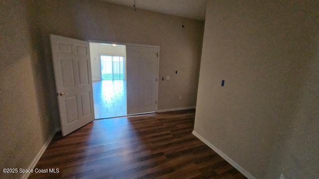 unfurnished room featuring dark wood-type flooring