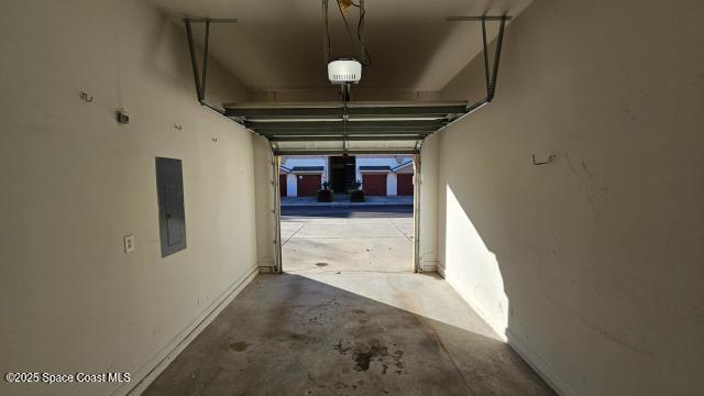 garage with electric panel and a garage door opener