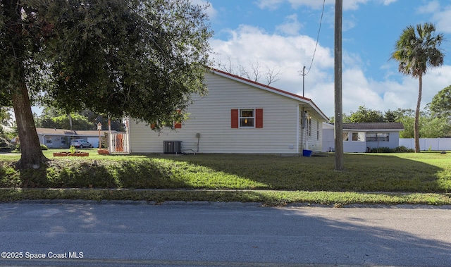 view of side of property with cooling unit and a lawn