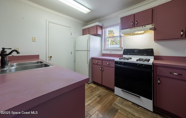 kitchen featuring white fridge, gas range, a textured ceiling, ornamental molding, and sink