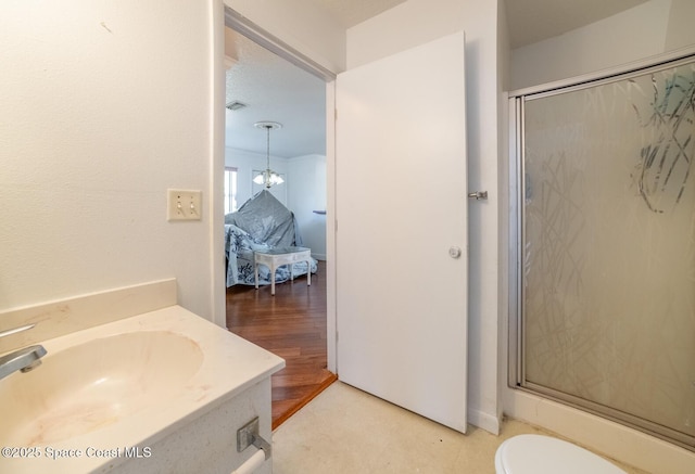 bathroom featuring hardwood / wood-style floors, walk in shower, vanity, and an inviting chandelier