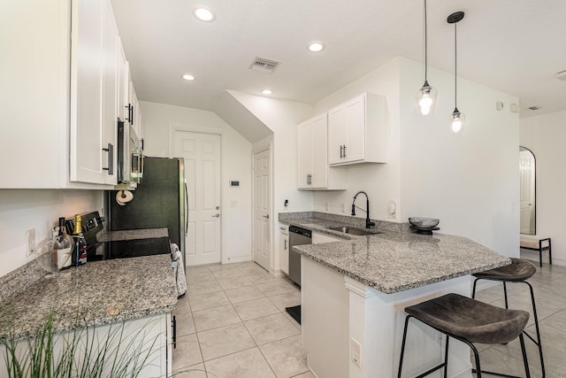 kitchen with white cabinetry, sink, stainless steel appliances, kitchen peninsula, and a breakfast bar area