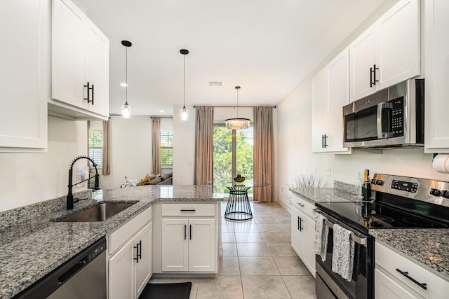 kitchen with white cabinetry, sink, stainless steel appliances, and decorative light fixtures