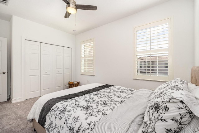 carpeted bedroom featuring a closet and ceiling fan