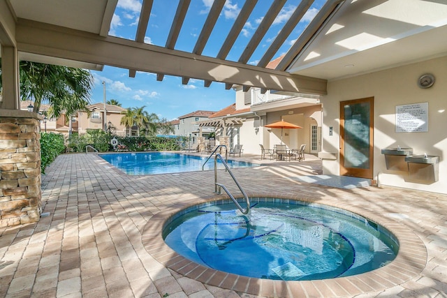 view of swimming pool with a community hot tub and a patio area