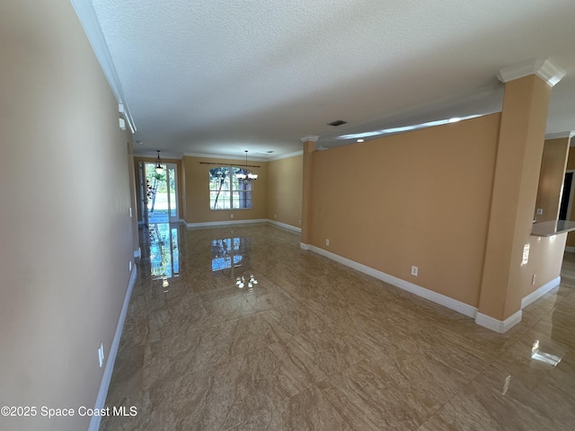 empty room with a textured ceiling, crown molding, and a notable chandelier