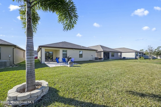 rear view of house with a patio area, a yard, and central AC