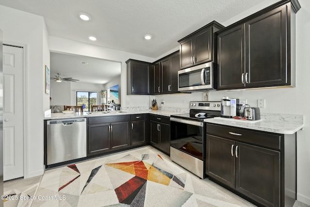 kitchen with dark brown cabinetry, ceiling fan, light tile patterned floors, and appliances with stainless steel finishes