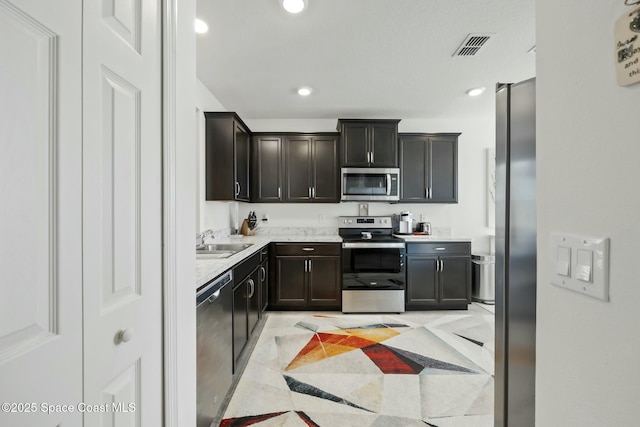 kitchen with dark brown cabinets, sink, and stainless steel appliances