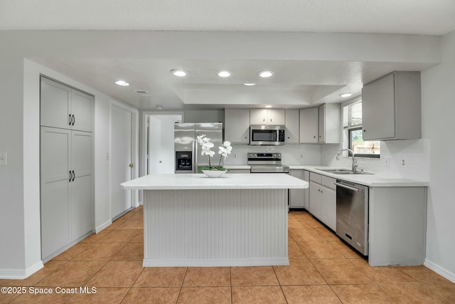 kitchen featuring gray cabinets, light tile patterned flooring, a kitchen island, sink, and stainless steel appliances