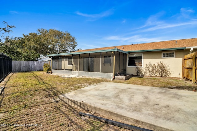 back of house featuring a sunroom, a yard, and a patio area