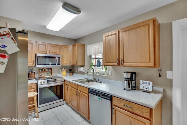 kitchen featuring light tile patterned flooring, light brown cabinets, stainless steel appliances, and sink