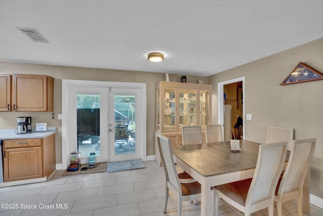 dining area with french doors and light tile patterned flooring