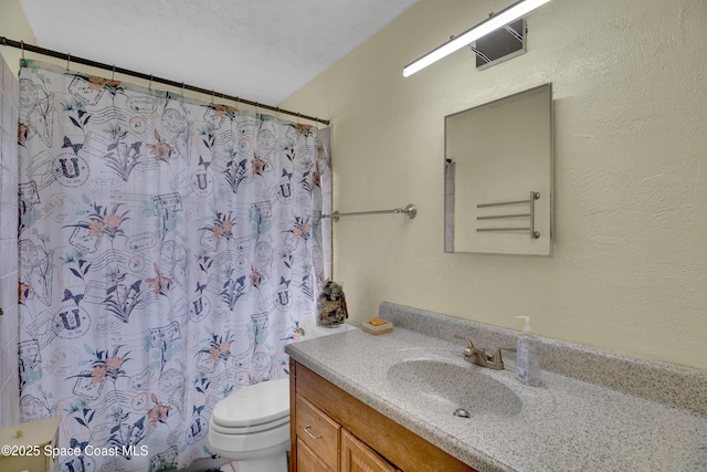 bathroom featuring a shower with curtain, vanity, a textured ceiling, and toilet