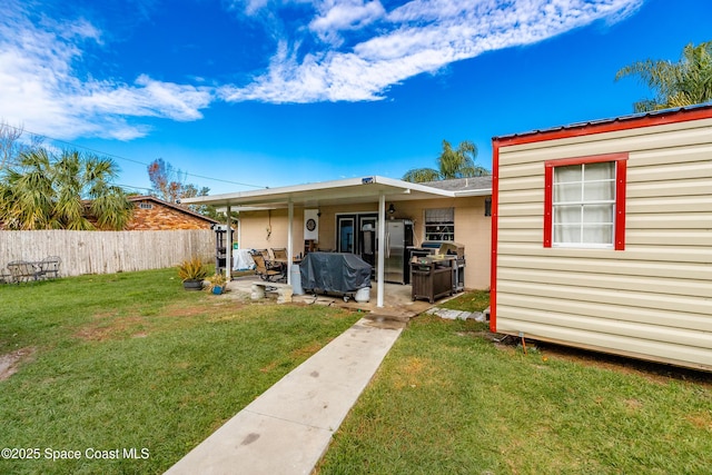 rear view of property with a lawn and a patio