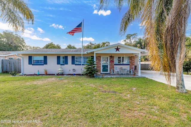 ranch-style home featuring covered porch and a front yard