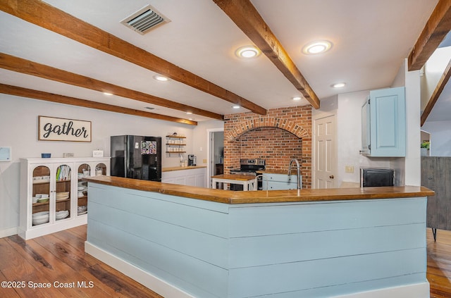 living room with sink, beamed ceiling, and wood-type flooring