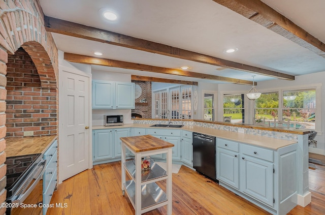 kitchen featuring pendant lighting, black appliances, sink, light hardwood / wood-style flooring, and a kitchen island