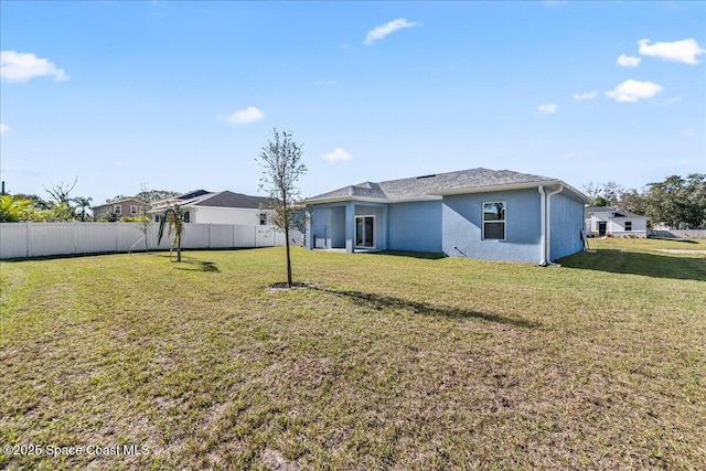 rear view of property with a yard