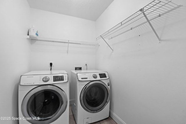 laundry room with hardwood / wood-style flooring and washer and clothes dryer