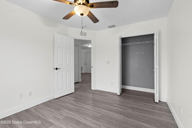 unfurnished bedroom featuring hardwood / wood-style floors, a closet, and ceiling fan